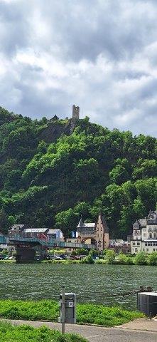 Eine Aussicht auf das Brückentor von der anderen Moselseite aus; man sieht oben auf dem Berg die Ruine Grevenburg