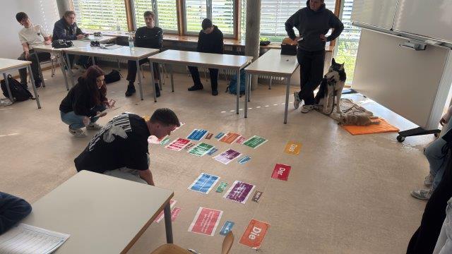 Schüler*innen setzen bunte Satzteile auf dem Boden zusammen