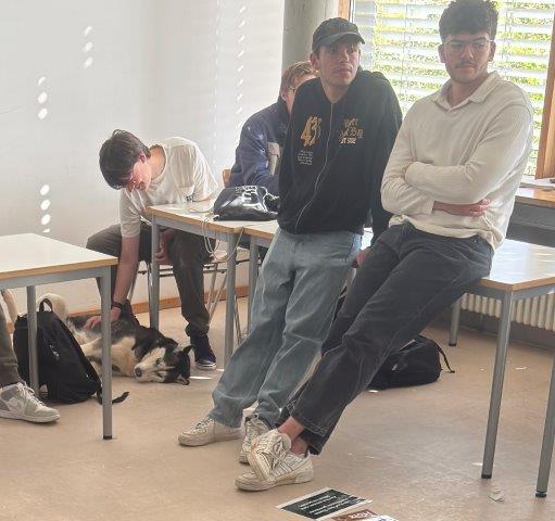 Schüler*innen auf oder am Tisch in der Klasse