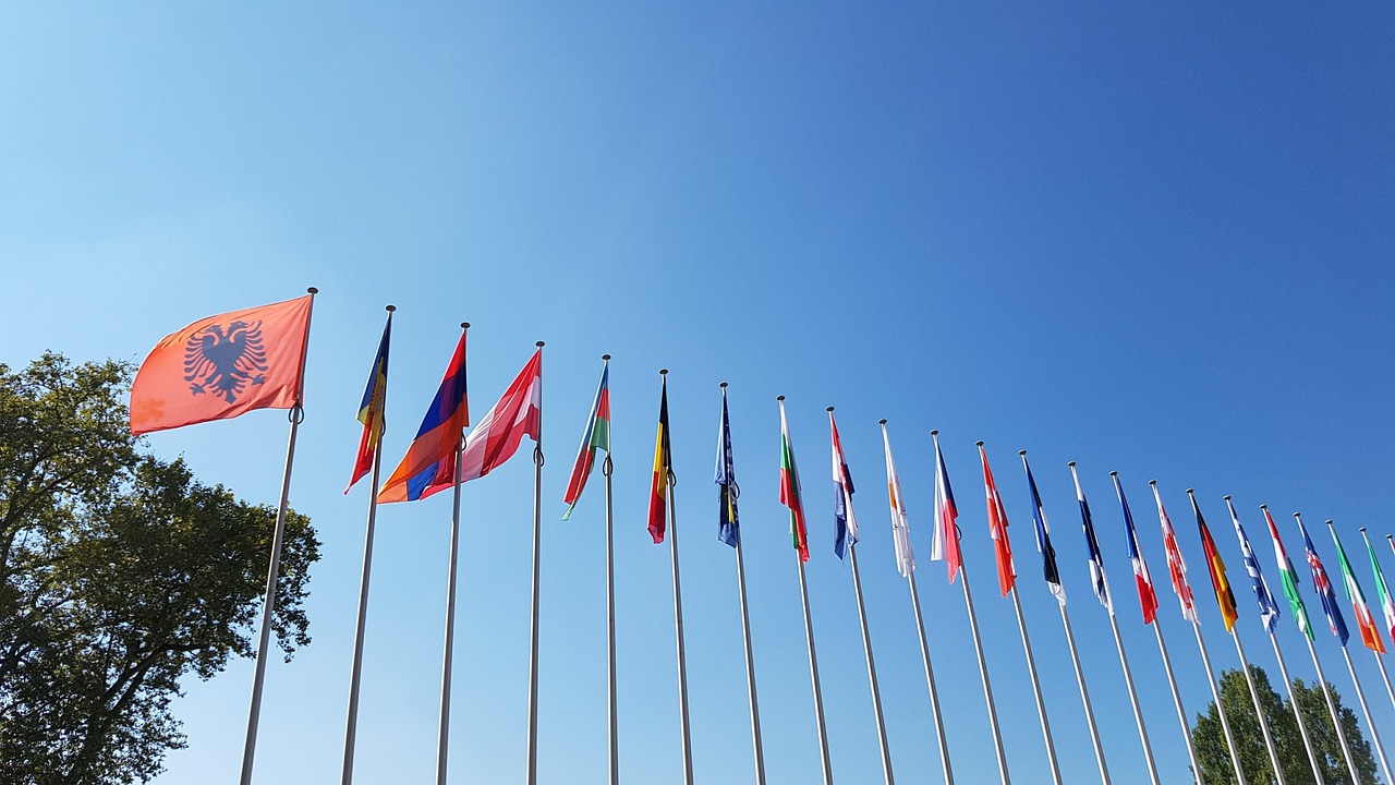 Man sieht eine Reihe Flaggen europäischer Länder vor blauem Himmel