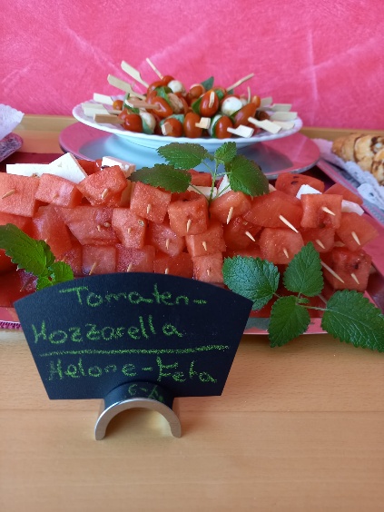 Auf dem Foto sind Melone-Feta-Spieße und Tomate-Mozzarelle-Sticks angerichtet