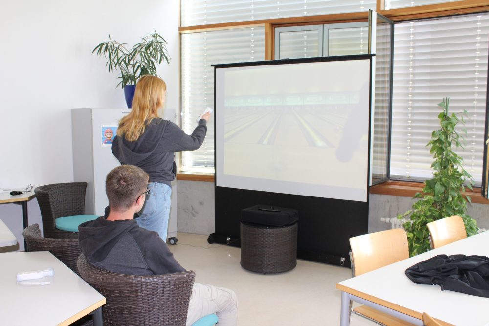 Eine Auszubildende spielt Wii Sports - Bowling