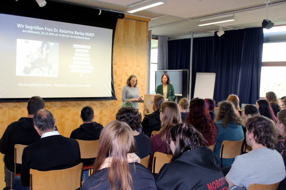 Das Foto zeigt den vollbesetzten Konferenzraum sowie Dr. Katarina Barley und Petra Sommer-Schmeichel am Rednerpult