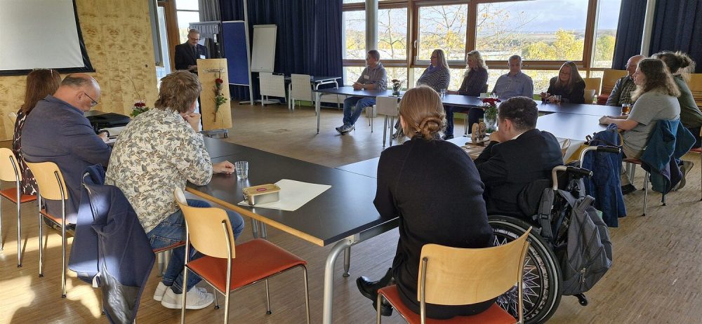 Alle Gäste sitzen an einer Tischgruppierung; der Vizepräsident der HWK steht am Rednerpult