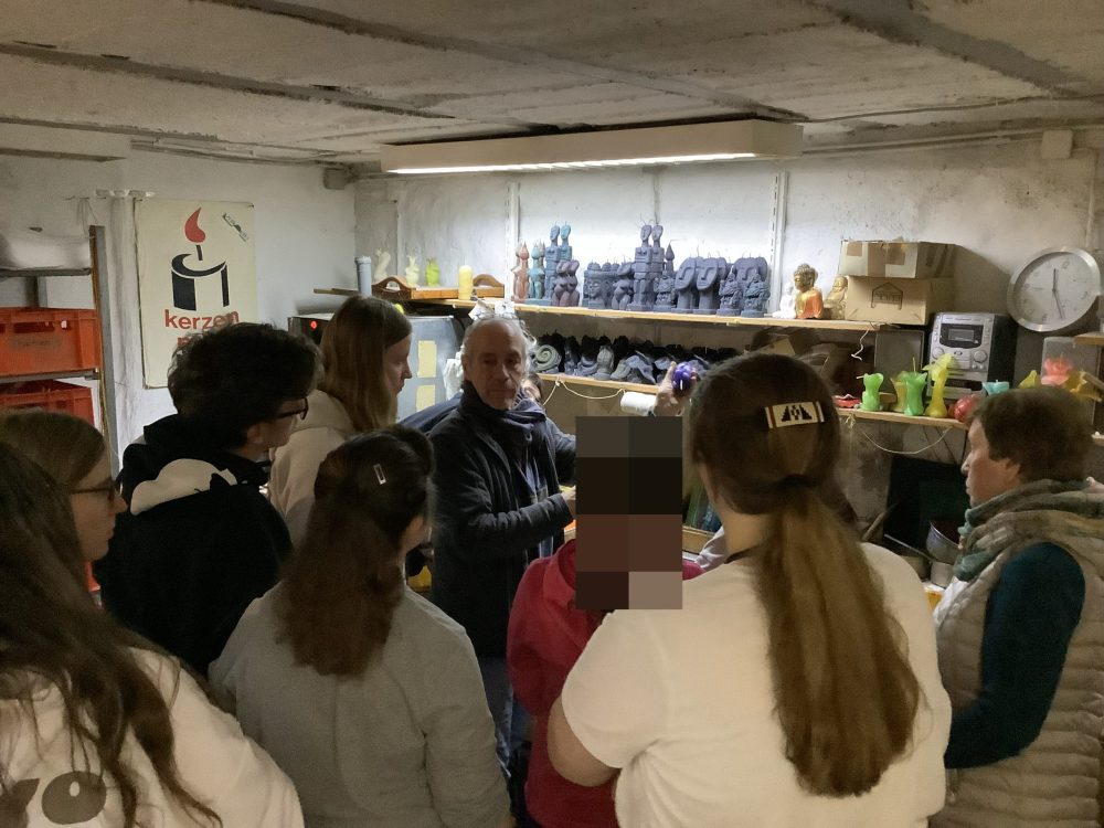 Eine Gruppe Auszubildender hört den Erklärungen von Herrn Moll zu