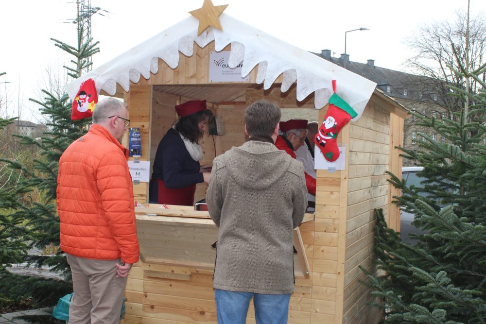 Zwei Personen vor, zwei in einer Verkaufsbude
