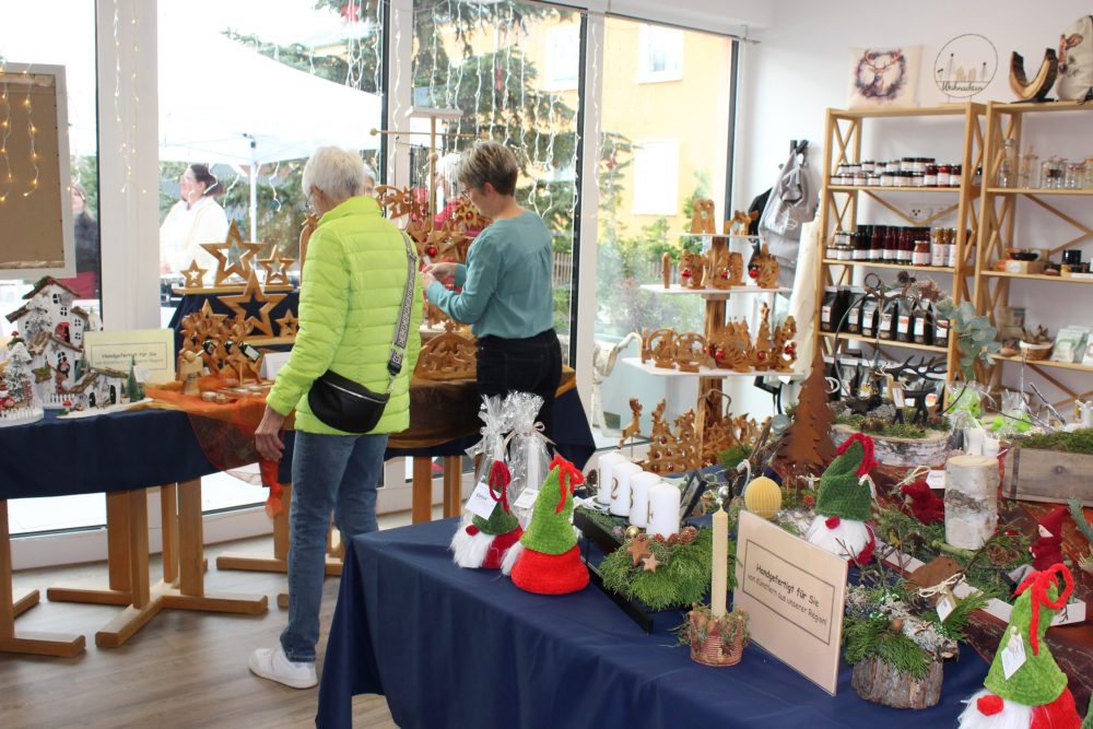 Zwei Personen schauen sich die selbstgemachten Holzartikel an