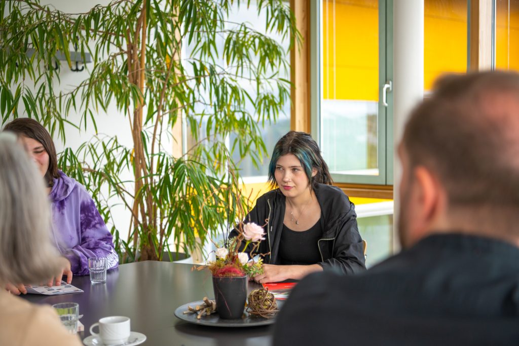 Vier Personen sitzen um einen Tisch