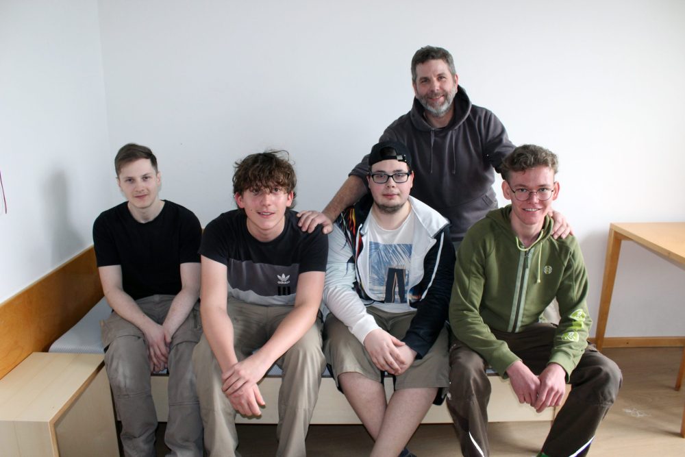 4 Auszubildende und ihr Ausbilder mit einem der neu gebauten Betten