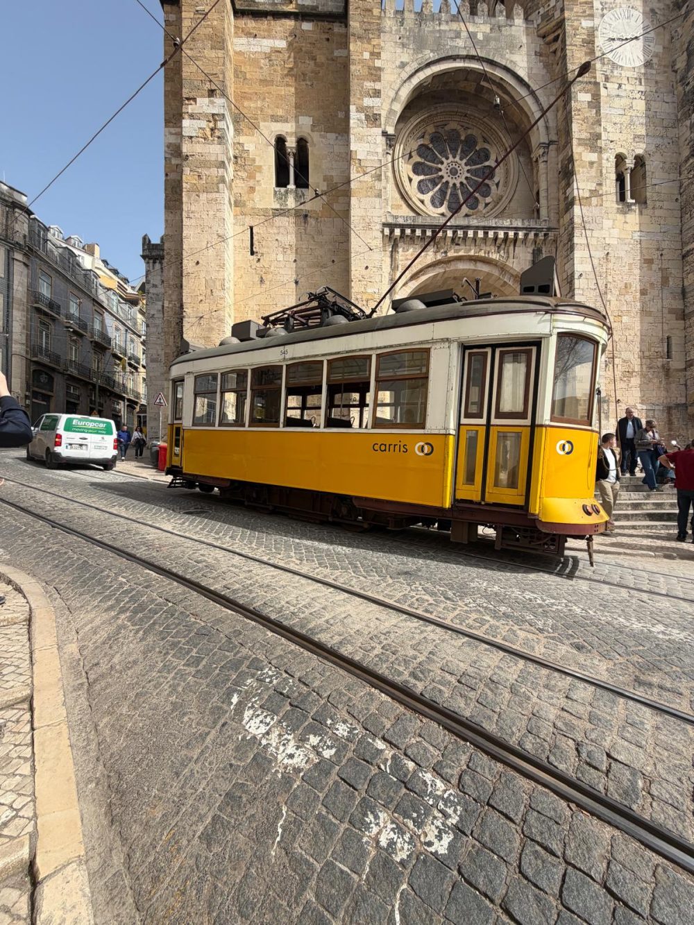 Die Kathedrale Sé de Lisboa von außen, als gerade die Tram 28 vorbei fährt