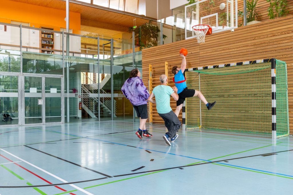 drei Personen spielen Basketball