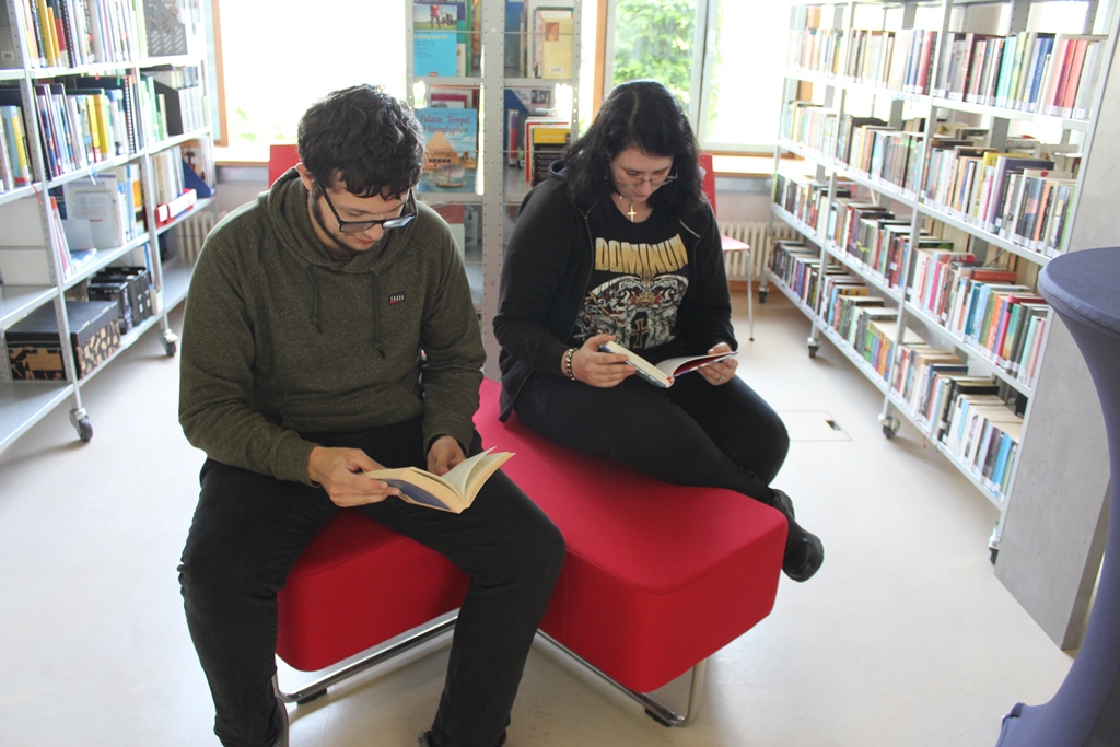 zwei Besucher*innen beim Lesen