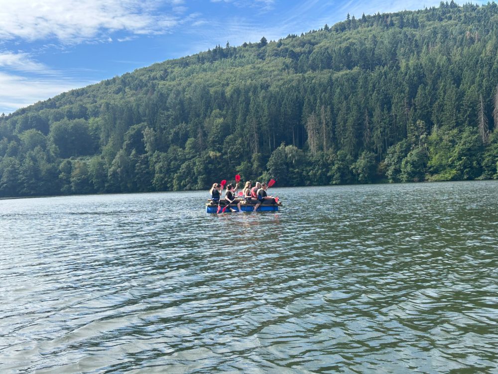 Die Teilnehmenden sind mit dem Floss auf dem See
