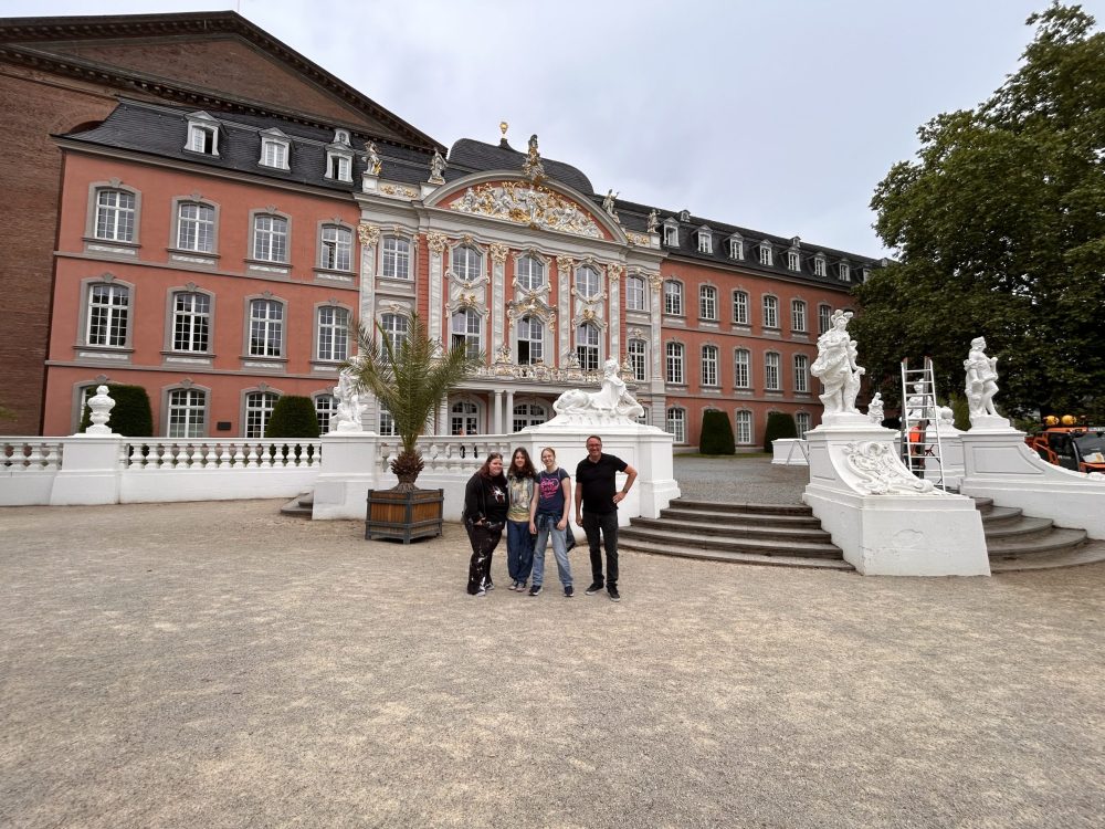 Vier Personen vor dem Kurfürstlichen Palais in Trier