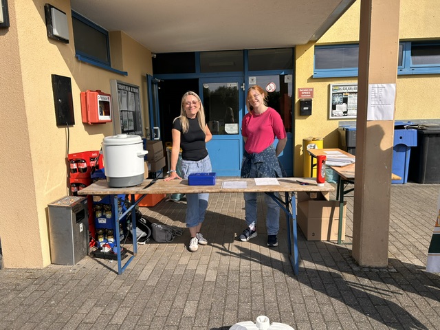 Blick auf den Sportplatz; im Vordergrund sind (verpixelte) Kinder abgebildet