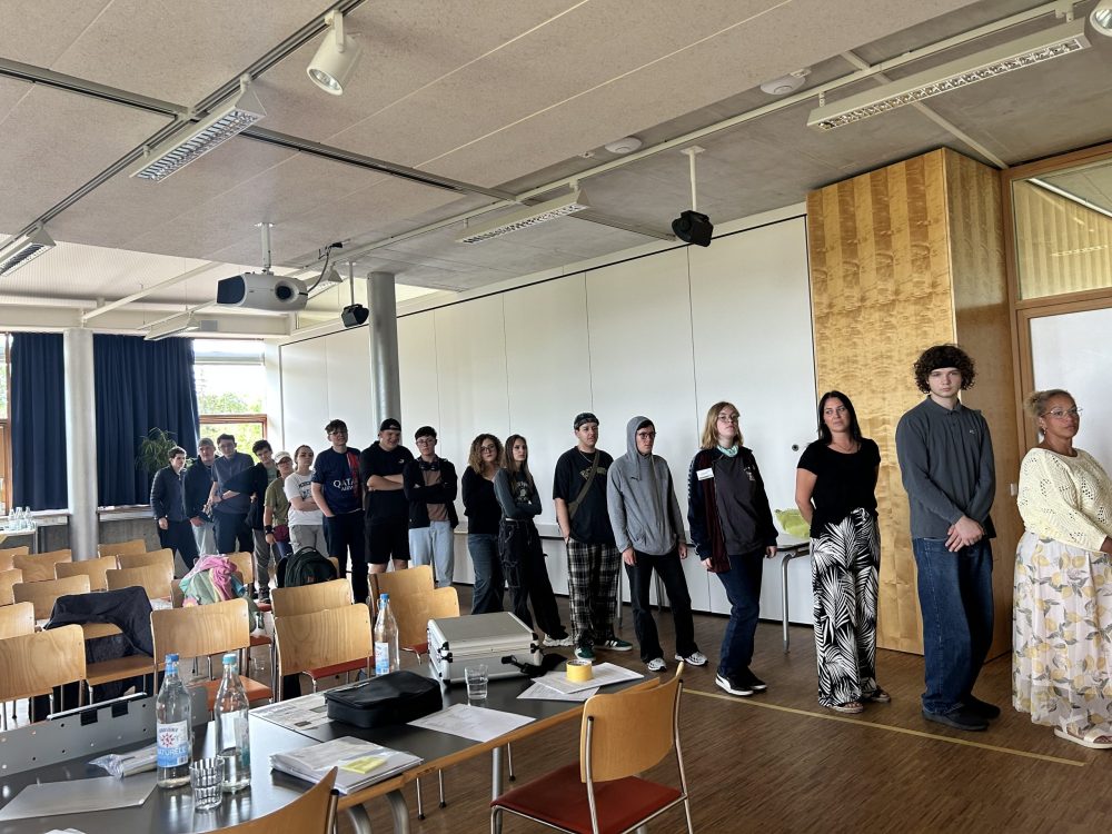 das Foto zeigt eine Gruppe von Teilnehmenden und Mitarbeitenden beim Aktivierungsspiel