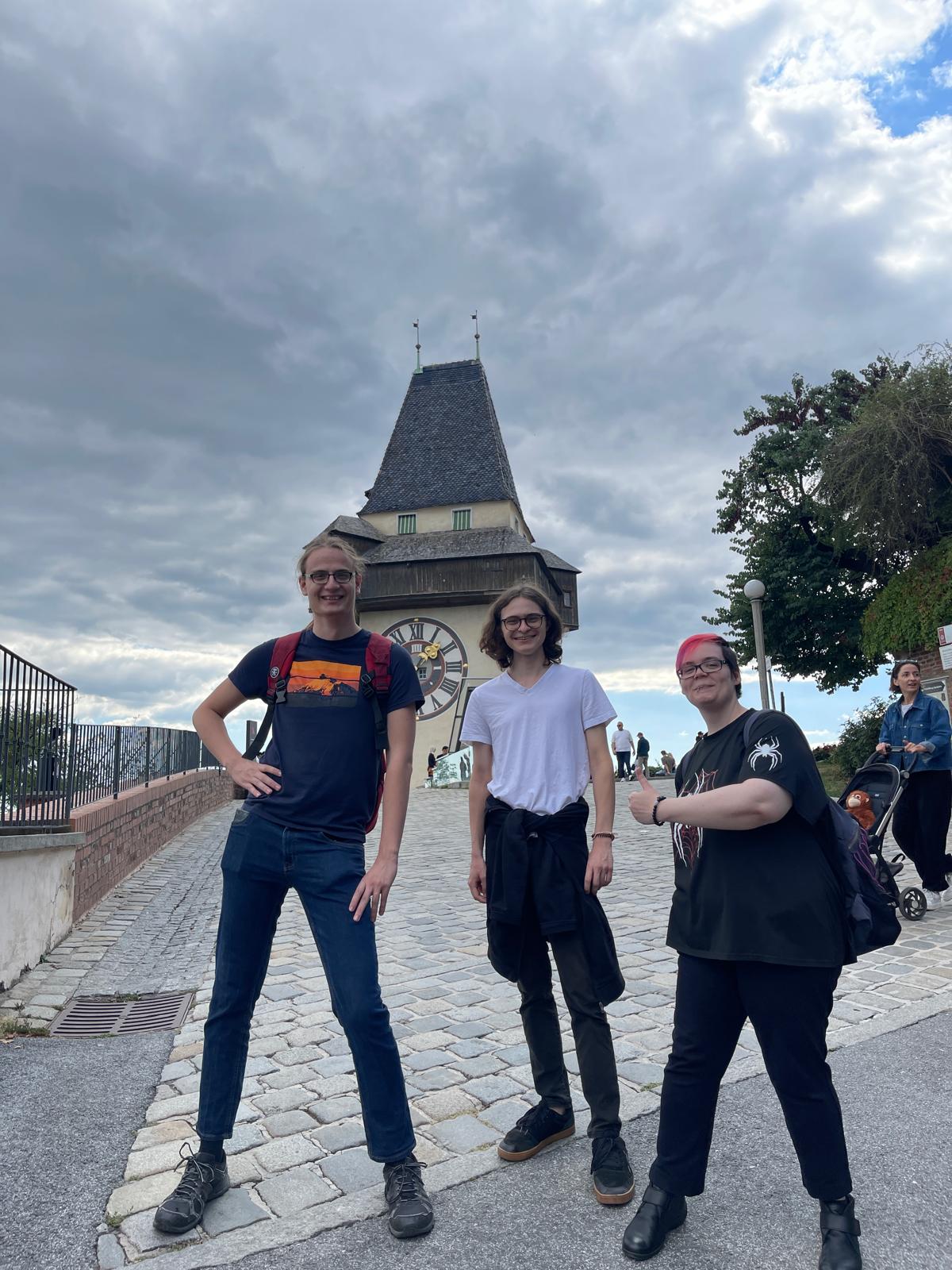 Unsere Praktikant*innen Ben, Hendrik und Thalia vor dem Uhrturm