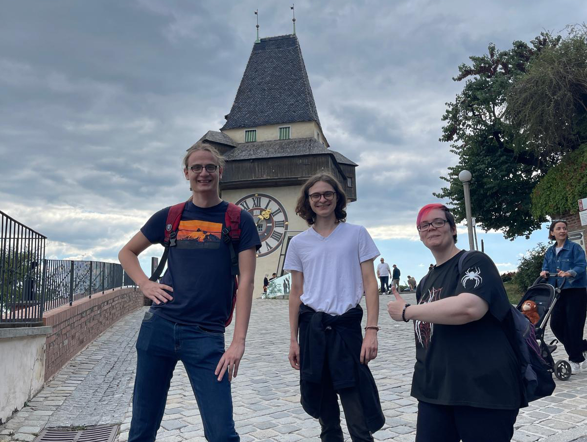 Unsere Praktikant*innen Ben, Hendrik und Thalia vor dem Uhrturm